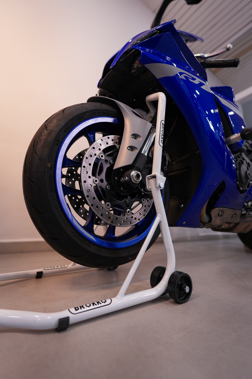Yamaha R1 azul apoyada sobre un caballete blanco Brokko