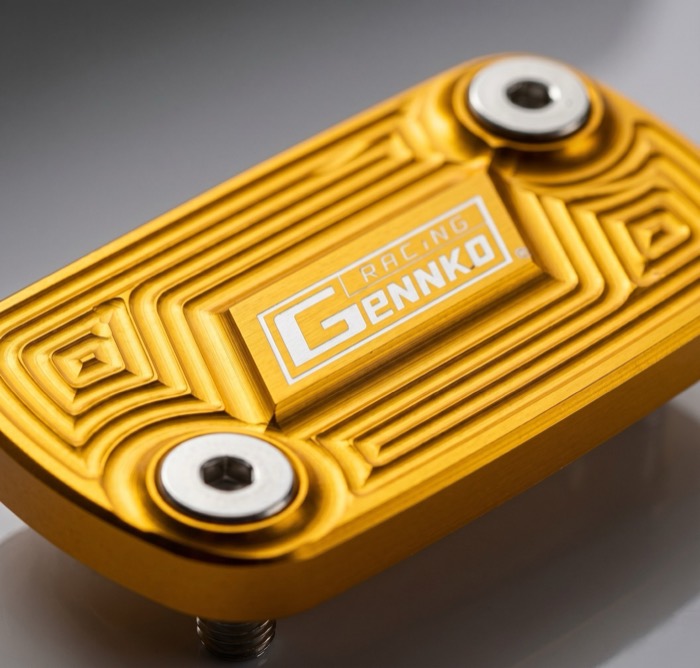 Tapa de depósito de freno dorada mecanizada en CNC, con el logo de Gennko Racing